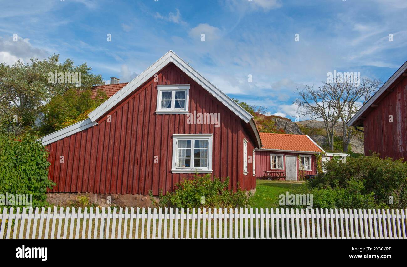 Rotes typisches Haus mit weißem Zaun davor in einem schwedischen Dorf Stockfoto