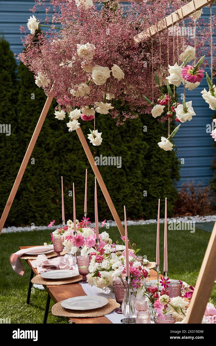 Pinkfarbene Tischdekoration für Gartenveranstaltungen. Inspiration für ein luxuriöses Picknick und Feierlichkeiten im Freien. Gartenparty im Sommer. Stockfoto