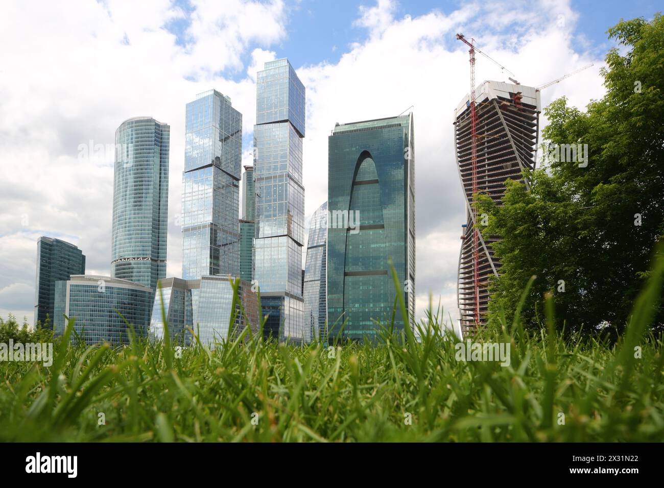 MOSKAU - 13. Juni: Stadtbild der Wolkenkratzer des Geschäftskomplexes Moskau-Stadt auf einem Hintergrund aus grünem Gras und blauem Himmel mit Wolken am 13. Juni 2013 in Stockfoto