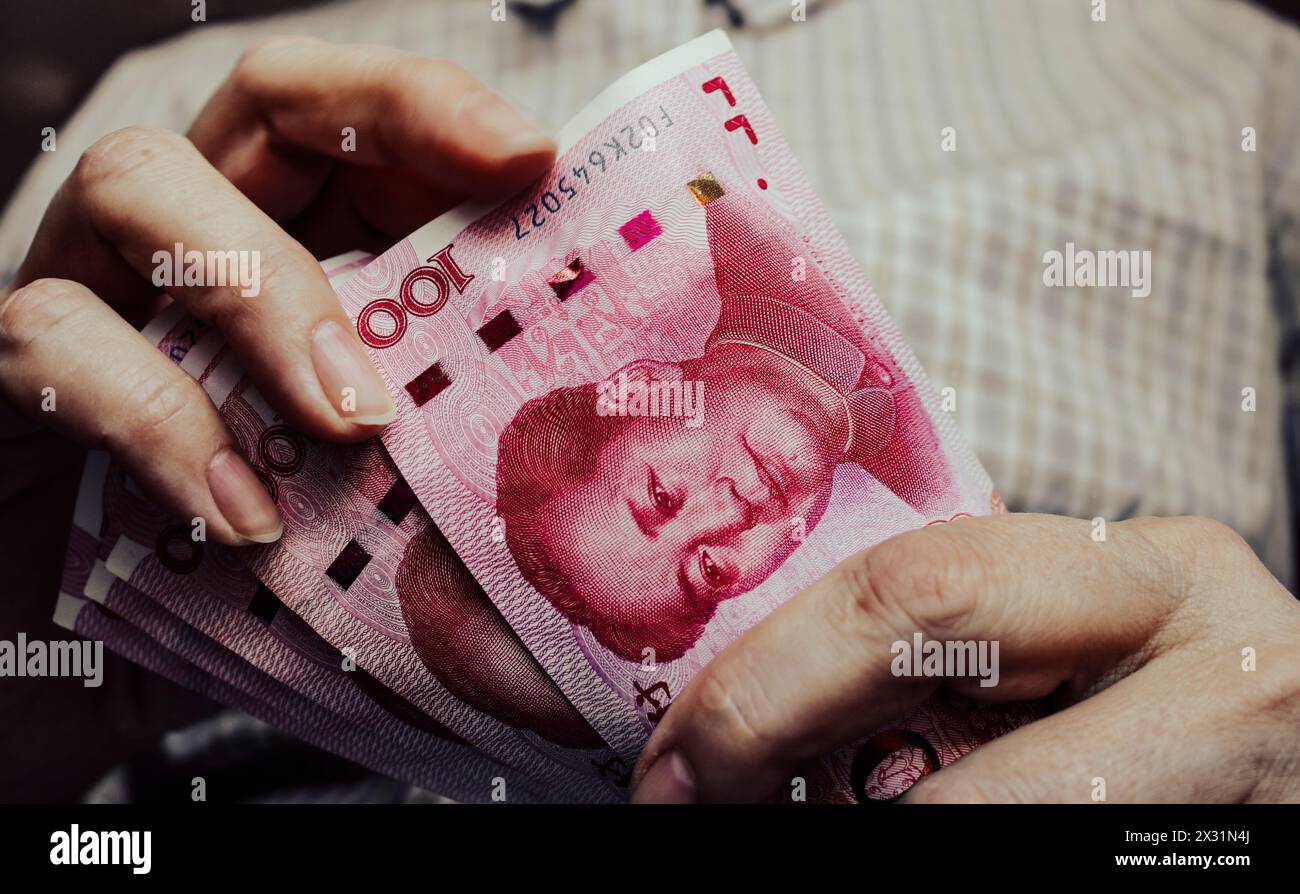 Chinesisches Geld in Händen, Vintage-Tonung. Yuan-Banknoten, Bargeld. Stockfoto