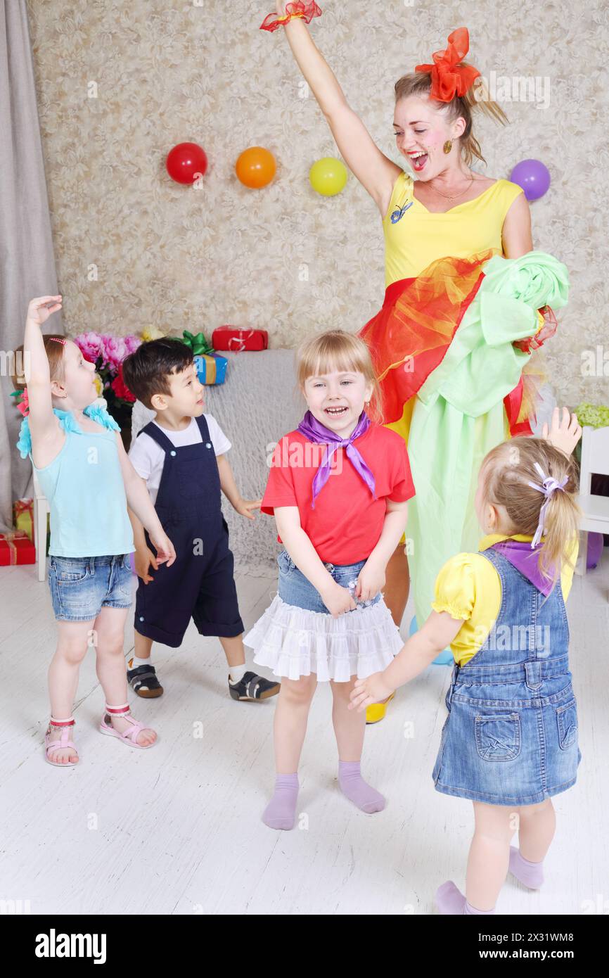 Vier Kinder und ein Vertreter der Feiertage spielen auf der Kinderparty. Stockfoto