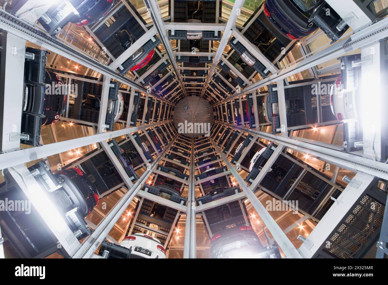 Bahnsteig mit Autos im Kreis im Turm im Zentrum bei Nacht. Der Turm wurde für mehrstöckige Parkplätze entworfen und gebaut Stockfoto