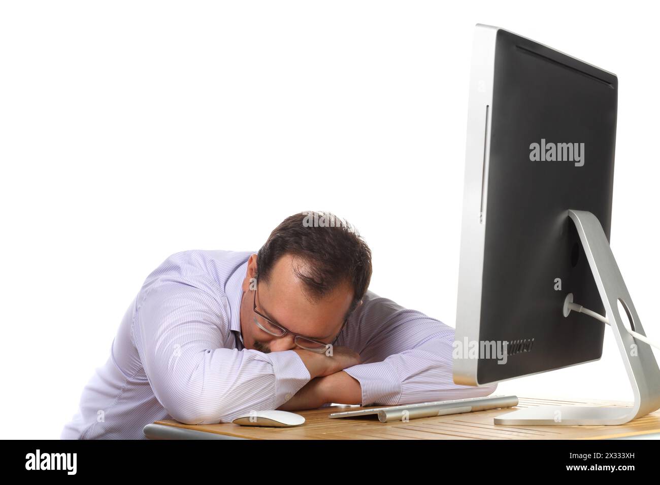 Ein müder Mann, der am Schreibtisch schlief und bis spät in die Nacht arbeitete Stockfoto