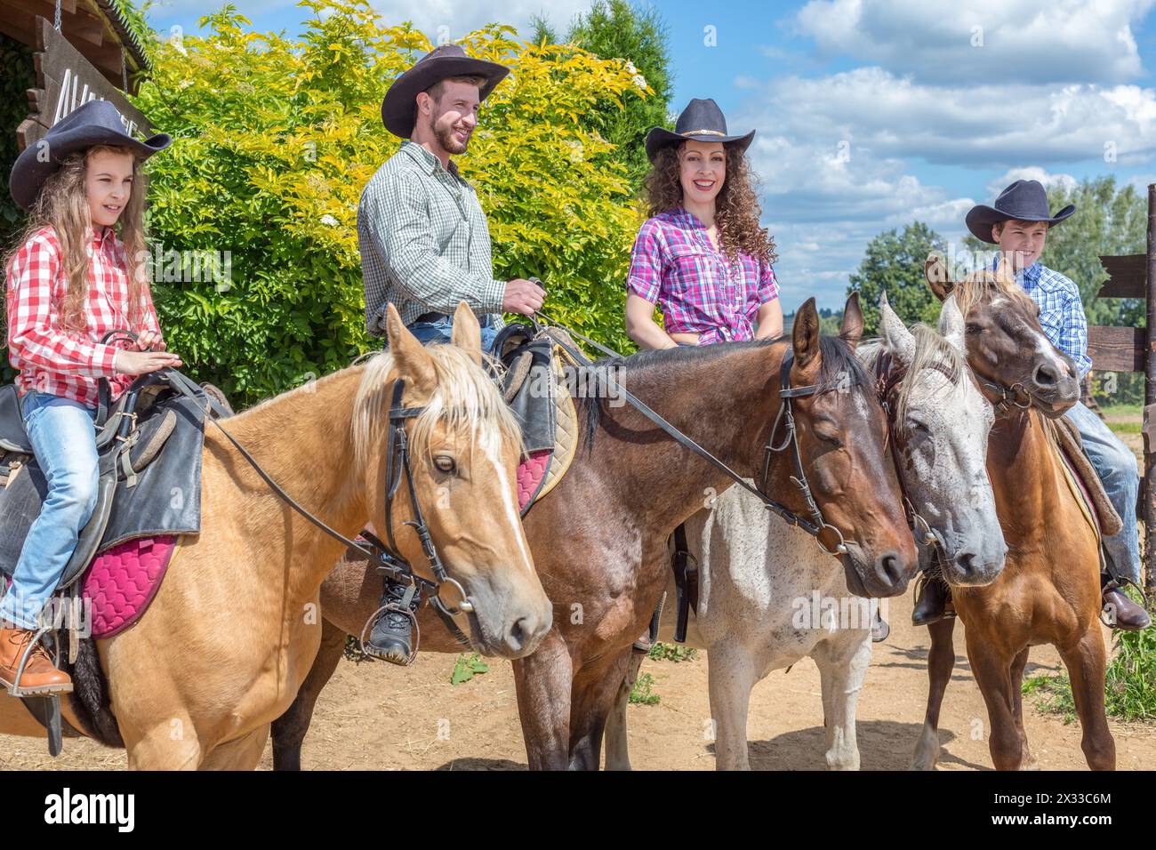 Vierköpfige Cowboyfamilie auf Pferden Stockfoto