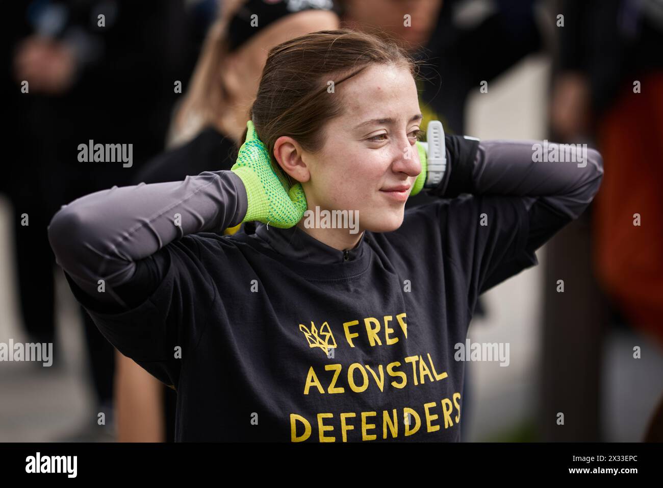 Porträt einer fröhlichen ukrainischen Frau, die beim Spartan-Rennen Dehnungsübungen macht. Kiew - 20. April 2024 Stockfoto