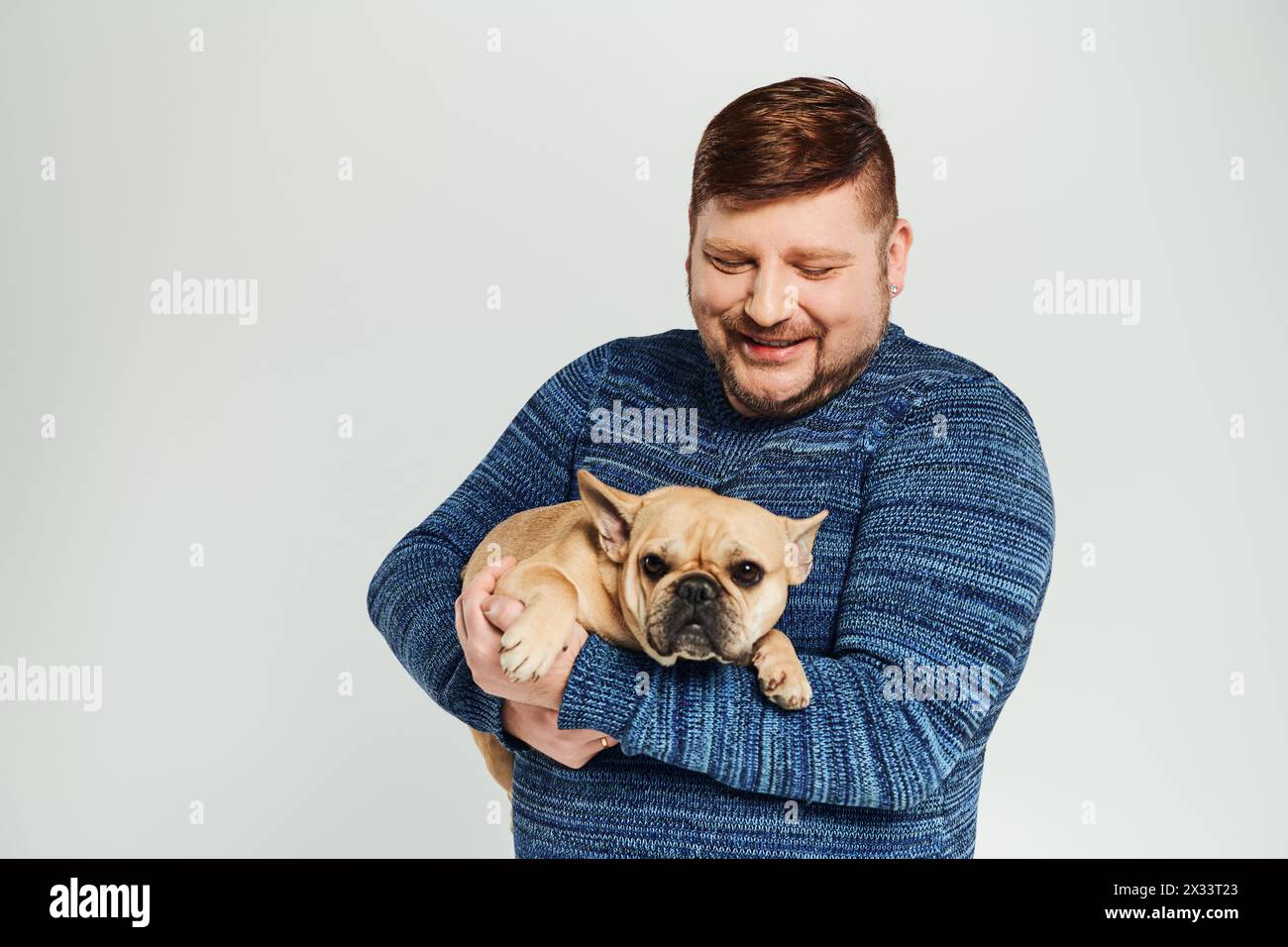 Ein Mann, der einen kleinen Hund zärtlich in den Armen hält. Stockfoto