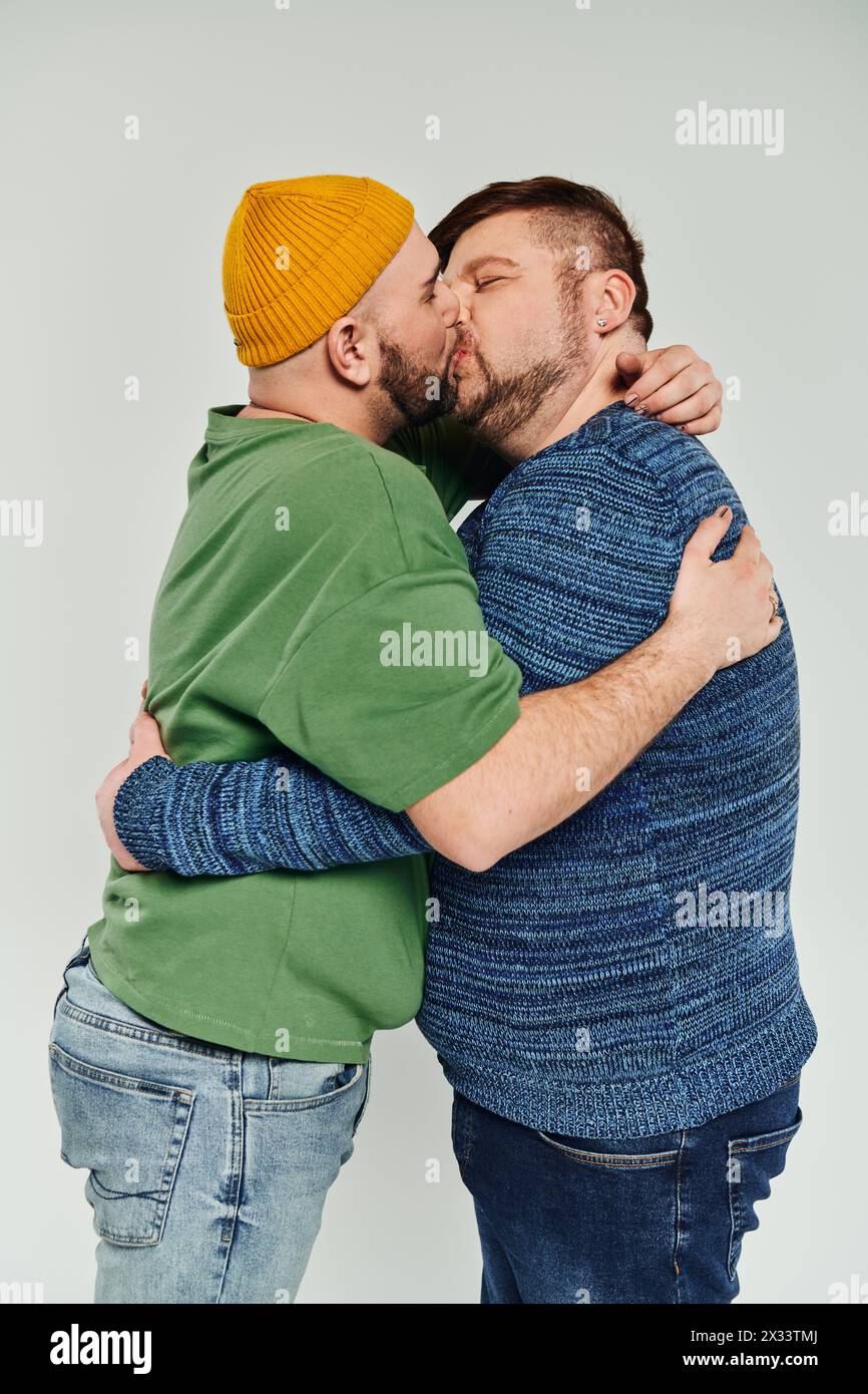 Zwei Männer küssen sich liebevoll vor weißem Hintergrund. Stockfoto