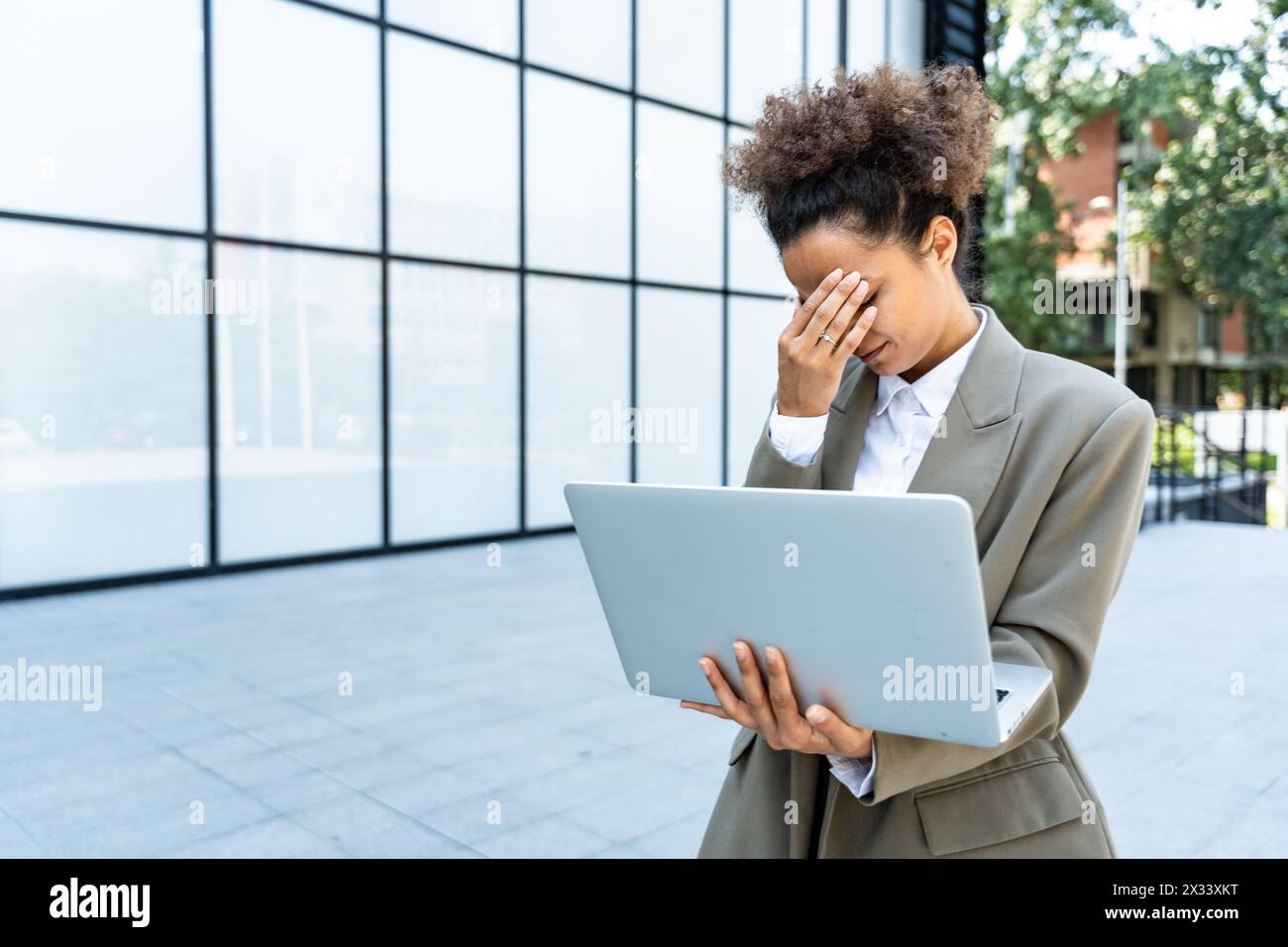 Porträt junger erfolgreicher Geschäftsfrau Büroangestellter mit Laptop-Computer außerhalb des Bürogebäudes in formeller Kleidung. Professionelles weibliches Business-pe Stockfoto