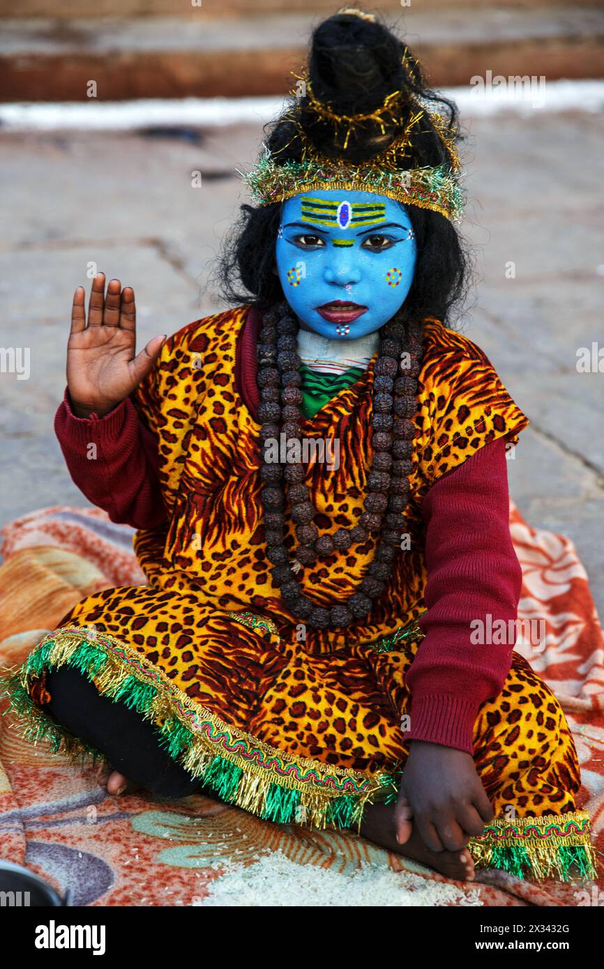 Kind als Shiva gekleidet mit blauem Gesicht in Varanasi, Indien Stockfoto