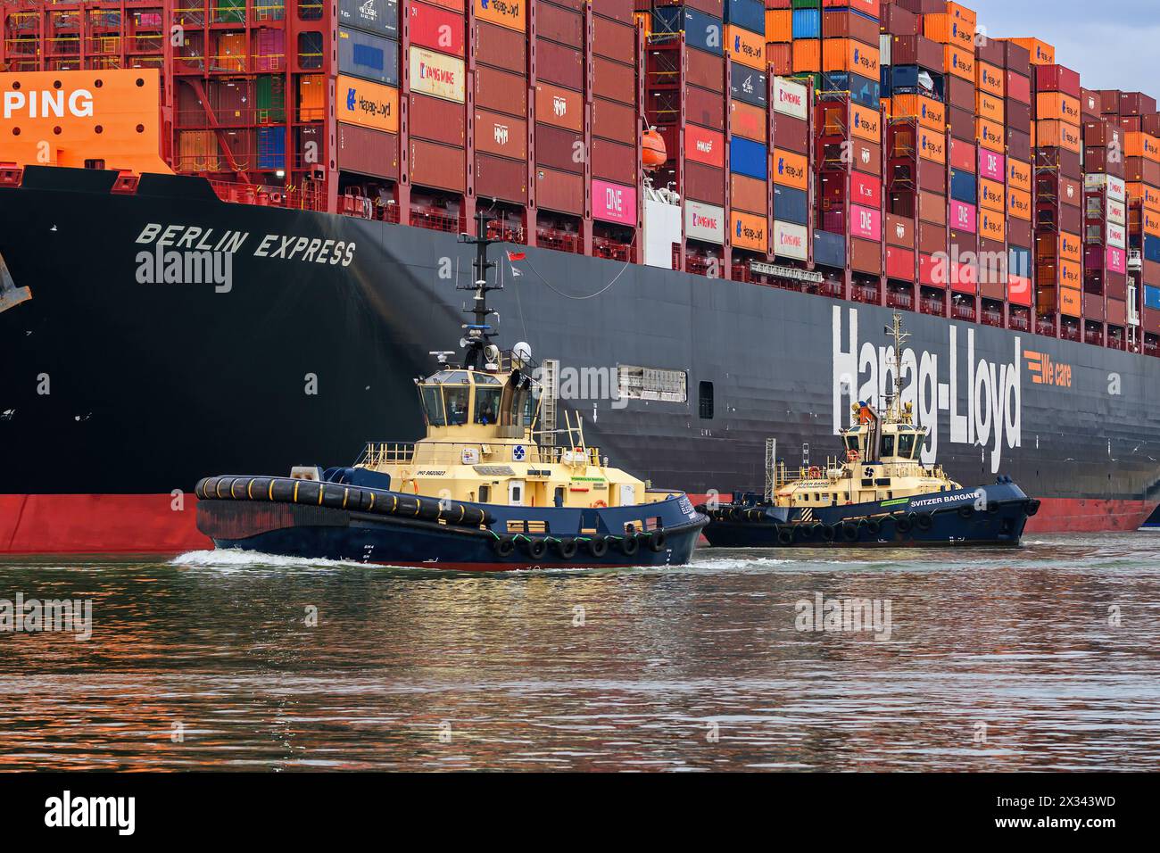 Svitzer Schlepper helfen beim Anlegen eines Containerschiffs im Hafen von Southampton. Stockfoto