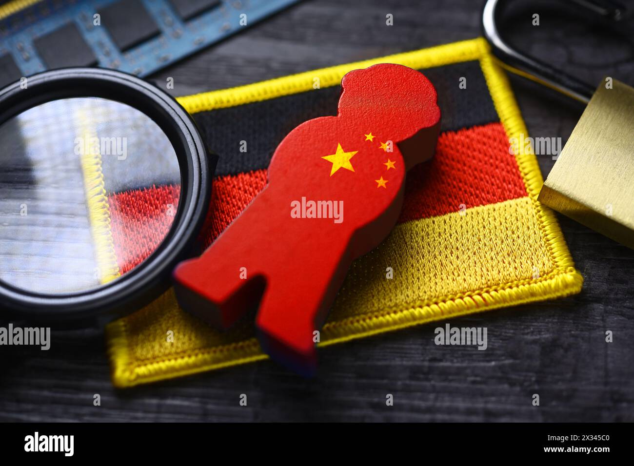 Figur mit chinesischer Flagge auf der Flagge Deutschlands, symbolisches Foto der chinesischen Spionage Stockfoto
