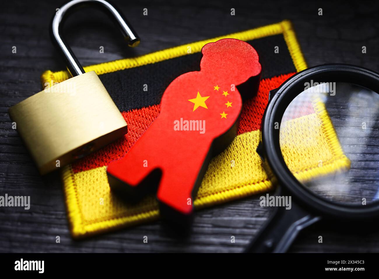 Figur mit chinesischer Flagge auf der Flagge Deutschlands, symbolisches Foto der chinesischen Spionage Stockfoto