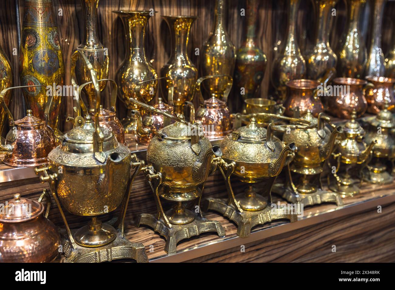 Alte Wasserkocher und Vasen mit geprägten Mustern stehen in Reihen auf dem Theken eines Straßenbazars in Buchara Stockfoto