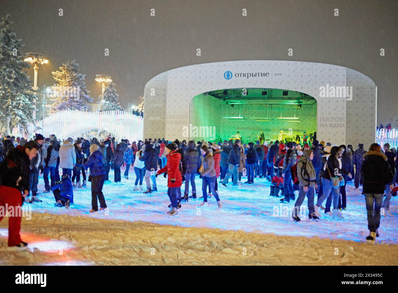 MOSKAU, RUSSLAND - 24. JAN 2015: Menschen auf der Eislaufbahn bei Schneefall am Abend in der VDNKh. Die Eislaufbahn in VDNKh ist die größte Eislaufbahn Europas – an Stockfoto