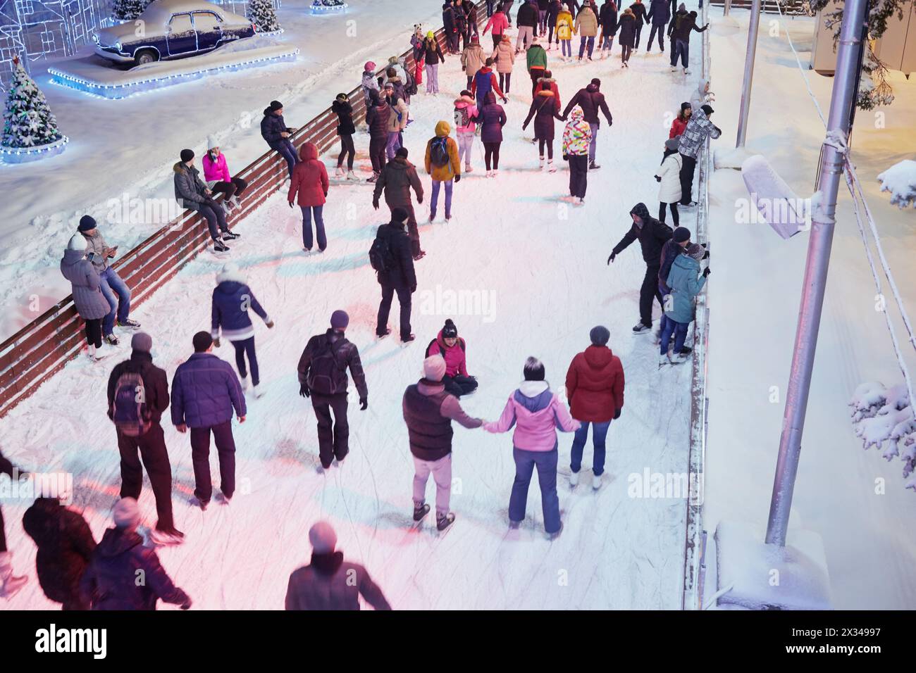 MOSKAU, RUSSLAND - 24. JAN 2015: Die Menschen haben sich abends auf der Eislaufbahn in der VDNKh ausgeruht. Die Eislaufbahn in VDNKh ist die größte Eislaufbahn Europas - ein Gebiet Stockfoto