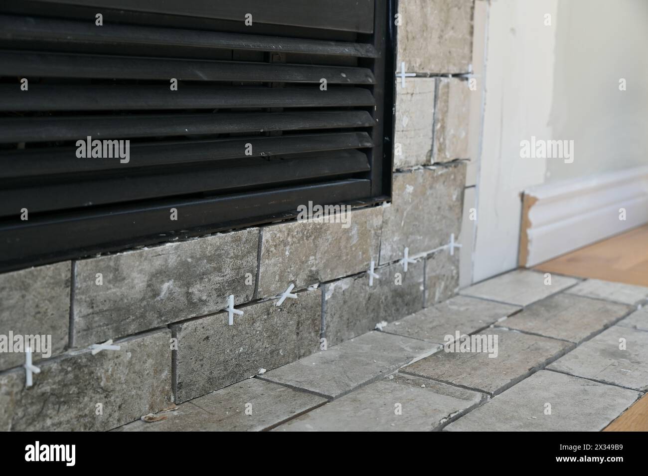 Haus-Renovierungsprojekt läuft, Wochenendfliesen zur Aktualisierung der Kaminumrandung Stockfoto