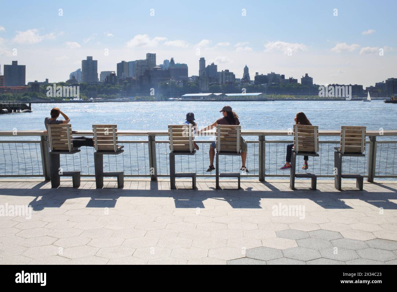 NEW YORK, USA - 7. September 2014: Die Menschen sitzen auf Stühlen und bewundern die Aussicht auf die Brooklyn-Seite von Manhattan Stockfoto