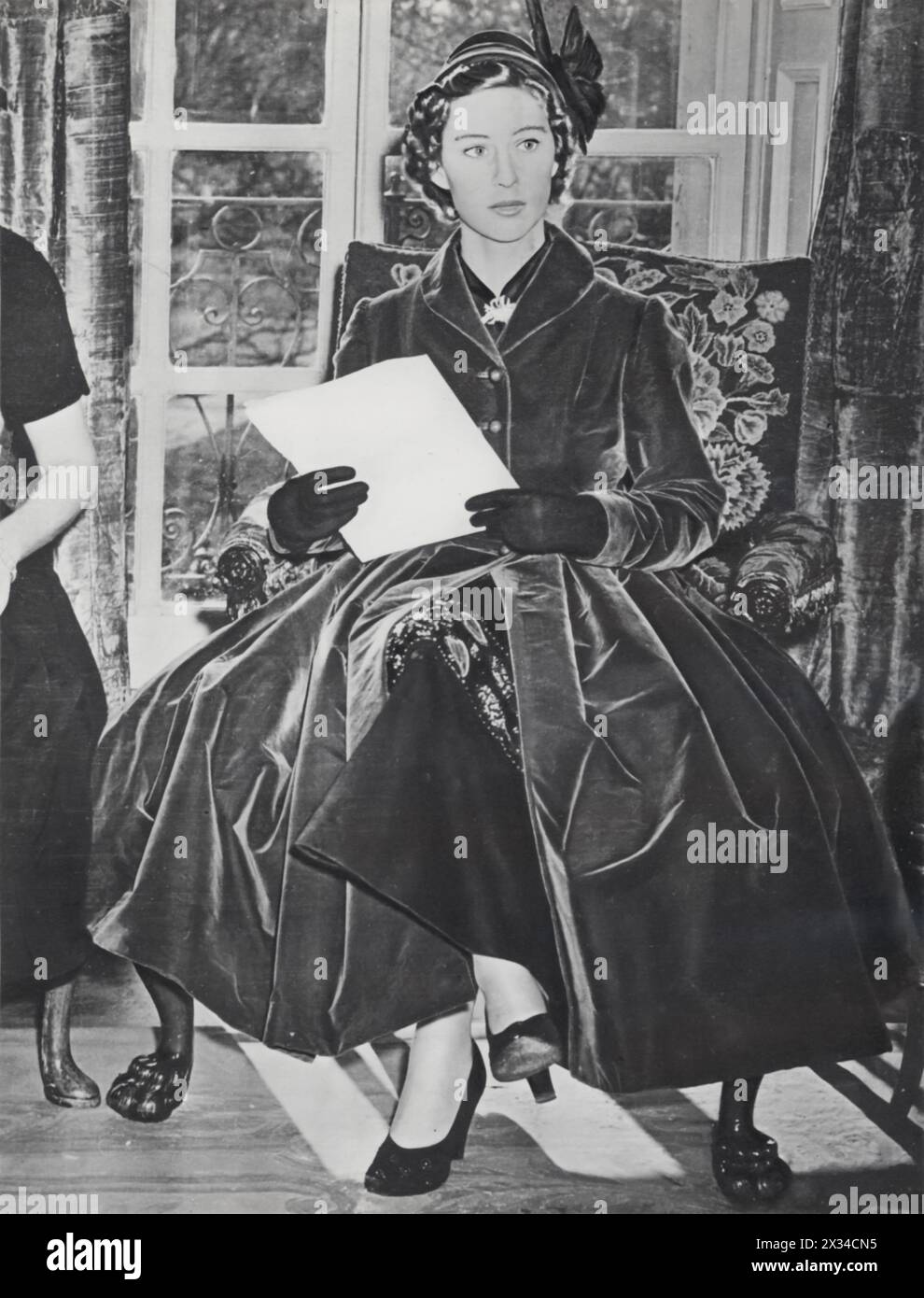 Prinzessin Margaret, Gräfin von Snowdon und jüngere Schwester von Prinzessin Elizabeth, wird 1951 bei der Londoner Fashion Designers Show gezeigt. Margaret, bekannt als Modeikone, wurde für ihre Stilentscheidungen gefeiert, einschließlich ikonischer Stücke von Christian Dior. Dieses Foto fängt ihren Einfluss in der Modewelt ein, ein Erbe, das sich über ihr Leben hinaus fortsetzte. Stockfoto