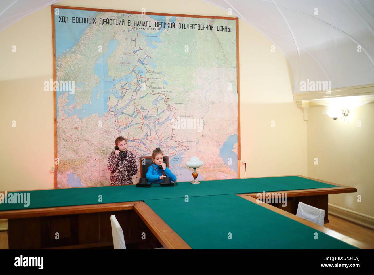 SAMARA, RUSSLAND - 8. MAI 2015: Mädchen, die ihr Handy am Tisch halten (Modelle mit Freigaben), im Stalins-Bunker mit großer Karte Stockfoto