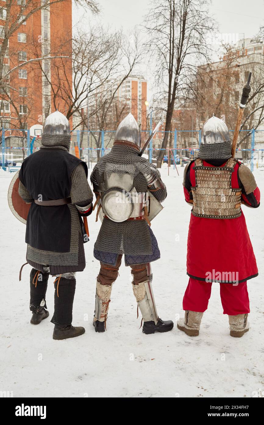 Im Winter stehen drei Männer in Verteidigungsritterkostümen im Hof. Stockfoto