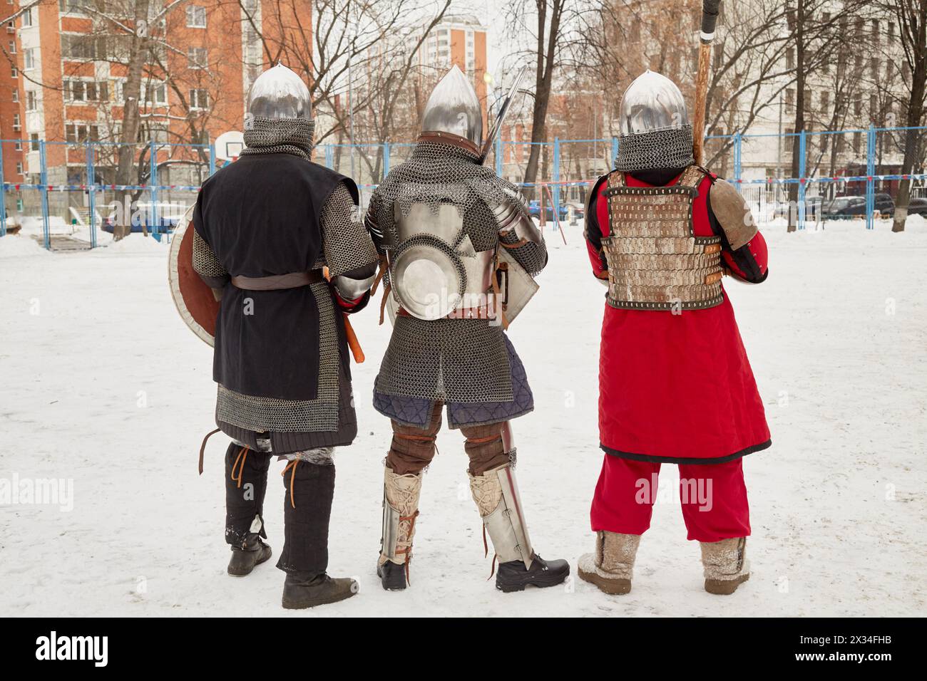 Im Winter stehen drei Männer in Verteidigungsritterkostümen im Hof. Stockfoto