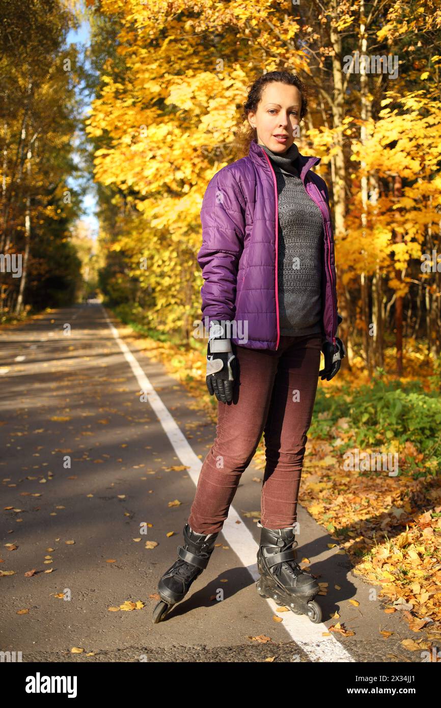 Porträt einer Frau auf Rollschuhen in vollem Wachstum im Herbstpark Stockfoto