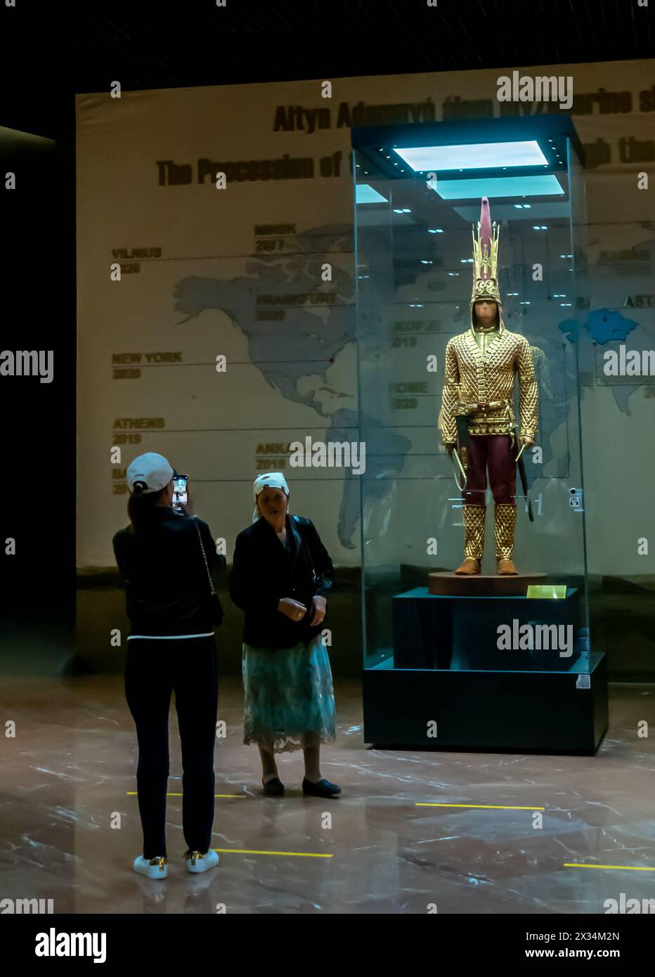 Besucher posieren vor Golden man, einem jungen edlen Saka-Krieger, 5-4. Jahrhundert v. Chr. Wiederaufbau von Kleidung und Ausrüstung, Museum in Astan Stockfoto