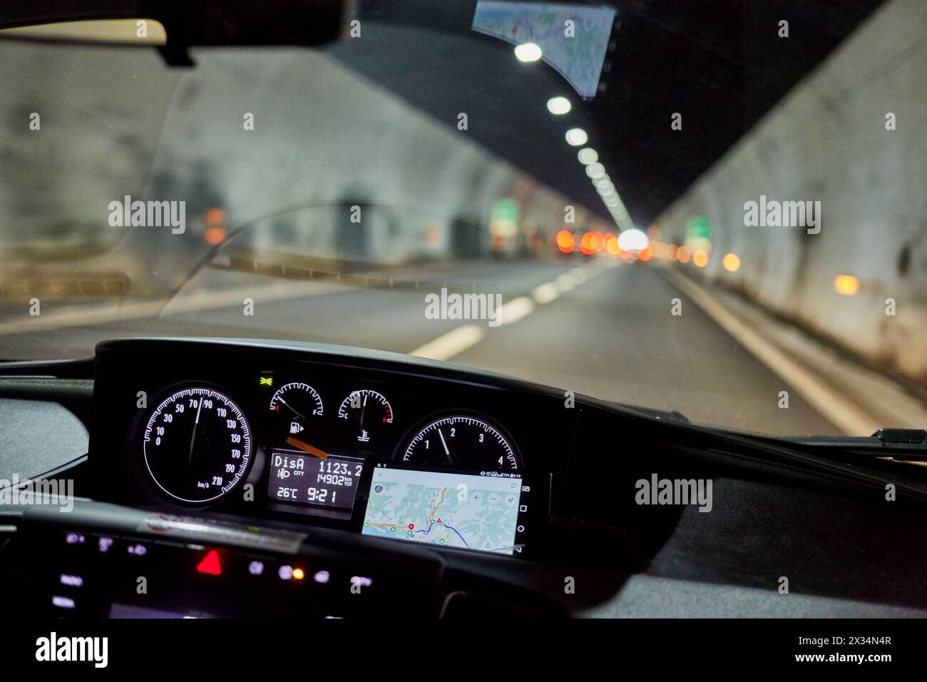 Blick durch die Windschutzscheibe des Autos, das sich im Tunnel auf der Straße bewegt. Stockfoto