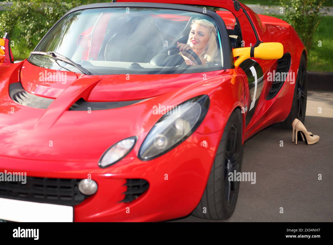 MOSKAU - 13. September 2015: Blonde Frau (mit Modellfreigabe) sitzt im Lotus-Cabriolet. Lotus Cars ist ein britischer Hersteller von Sport- und Rennwagen Stockfoto