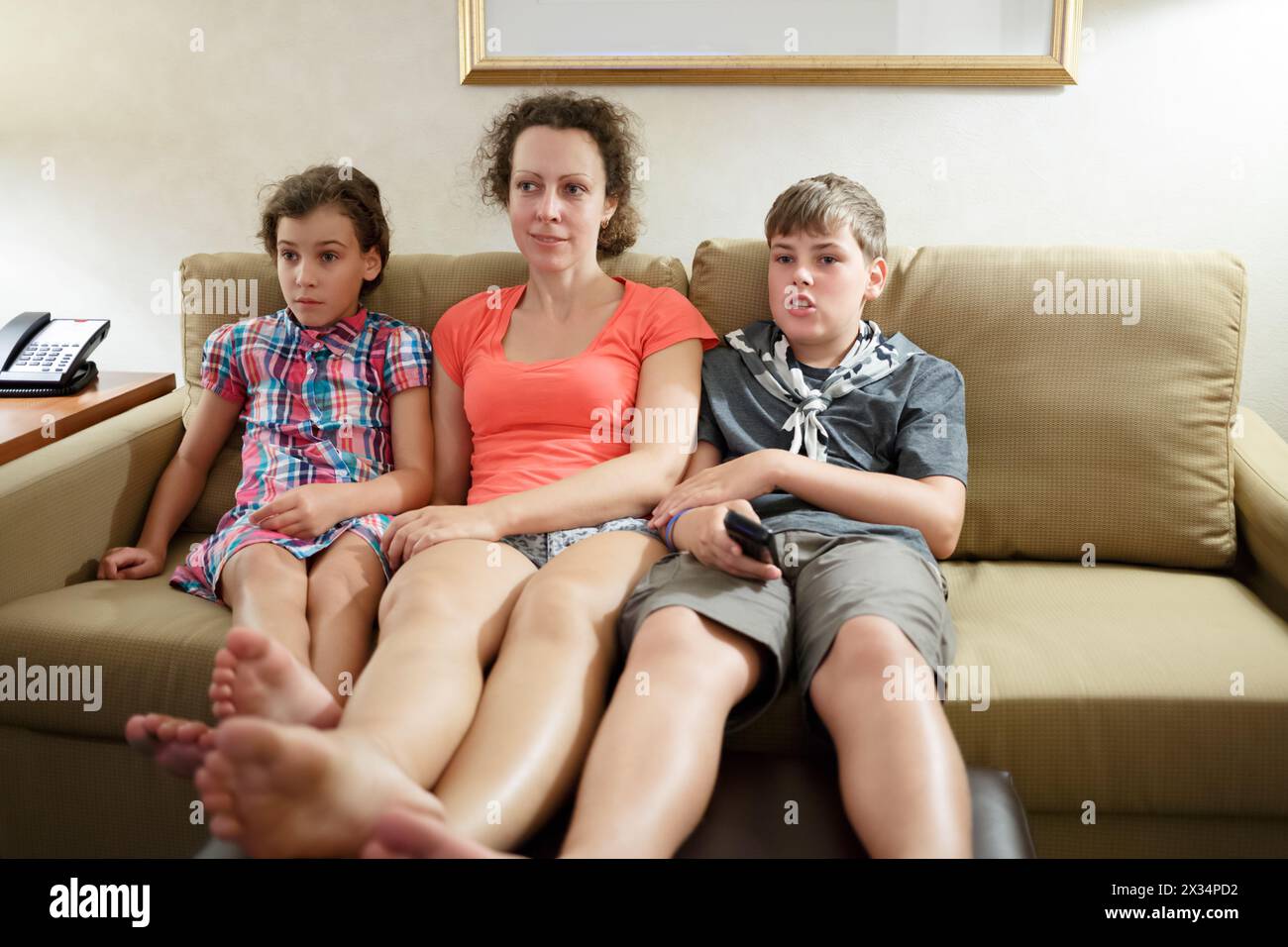 Mutter mit zwei Kindern, die in einem Bus fernschauen Stockfoto