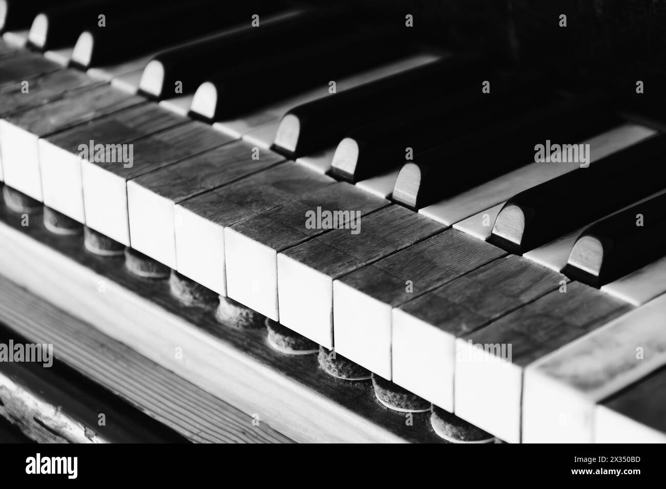 Sehr altes Klaviertastatur mit den Zeichen der Zeit. Alte Tasten mit Dreck auf altem Holzflügel. Vintage-Musikinstrument. Kreativitätskonzept Stockfoto