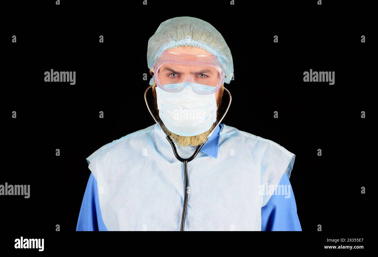 Krankenhausarbeiter. Ernsthafter Arzt in medizinischer Uniform, Maske, Schutzbrille und Einweg-OP-Kappe. Chirurgenarzt in medizinischer Maske und Peelings Stockfoto