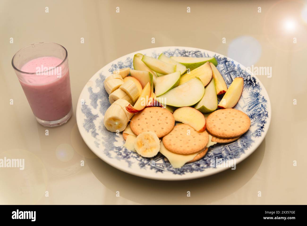 Teller mit Banane, Apfel, Birne, Keksen, Käse und Joghurt. Gesundes Frühstück. Diät Stockfoto