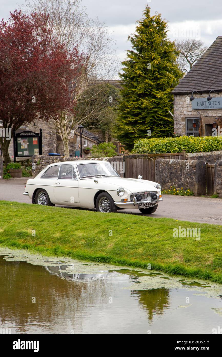 1967 Oldtimer MG B GT parkt am Dorfteich im Dorf Hartington, England, Großbritannien Stockfoto