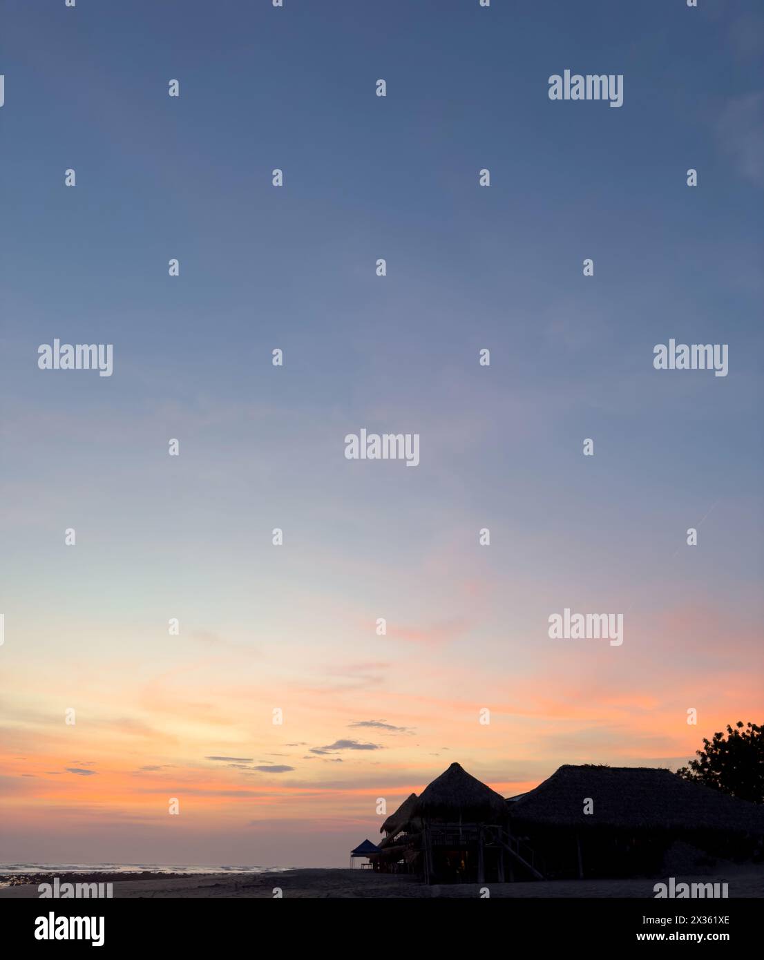 Tropisches Resort am Strand bei Sonnenuntergang Himmel Hintergrund Stockfoto