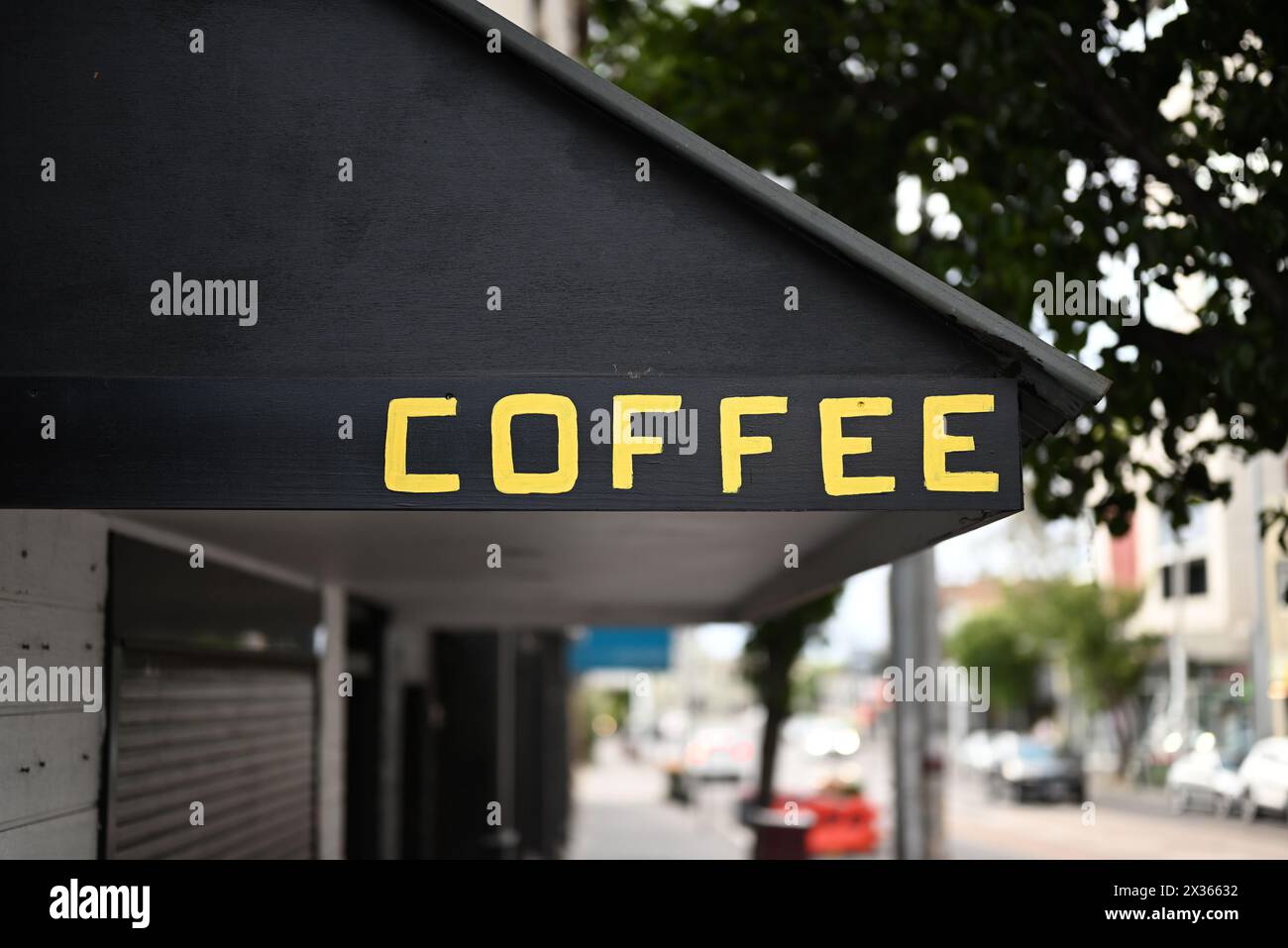 Das Wort Kaffee in gelben Blockbuchstaben oder Großbuchstaben auf einem schwarzen Markise über einem Geschäft oder Café Stockfoto