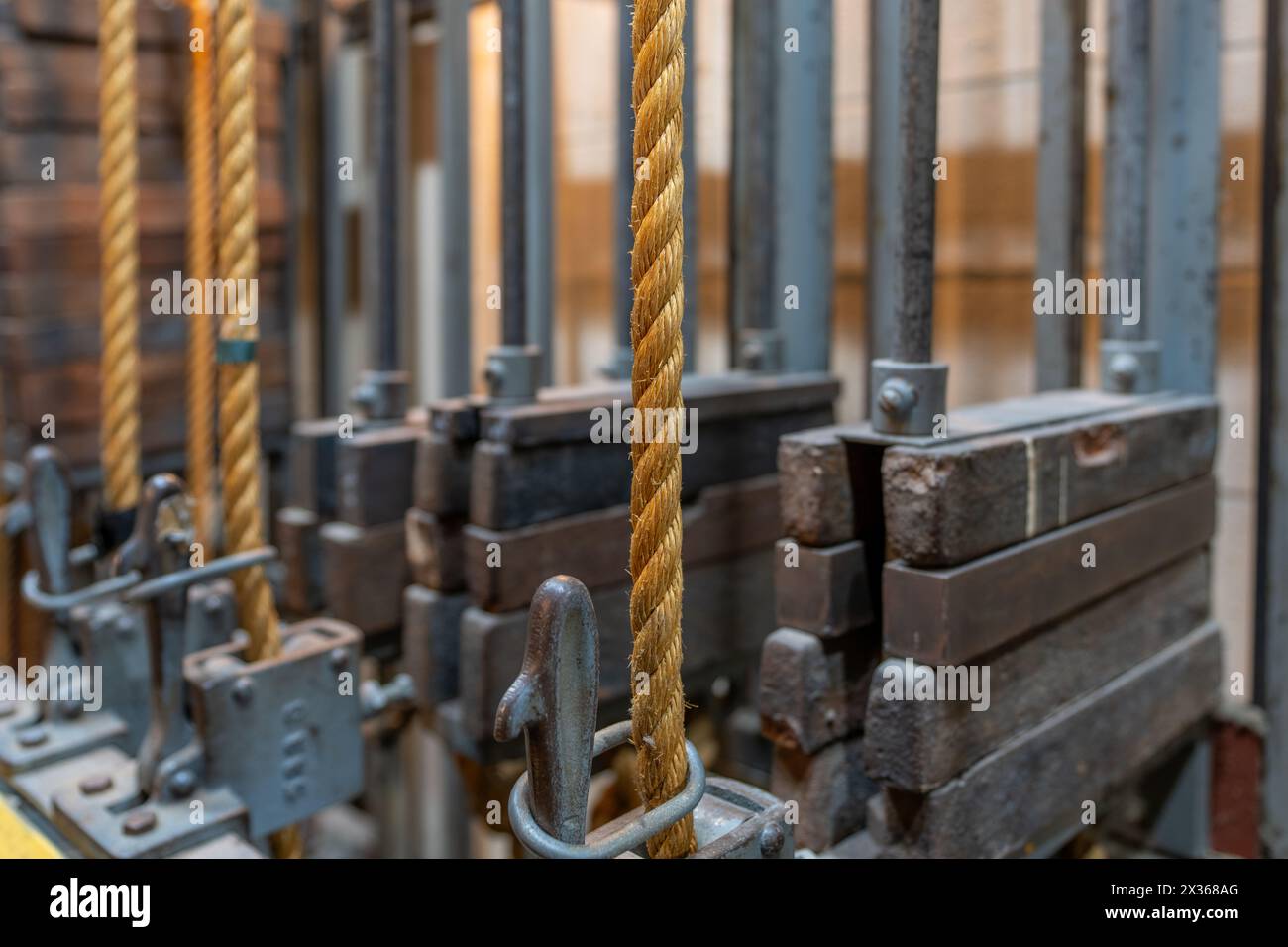 Älteres Theater-Rigging-System mit verdrehtem manila-Seil und Gewichten, die hinter der Bühne gefunden wurden. Stockfoto