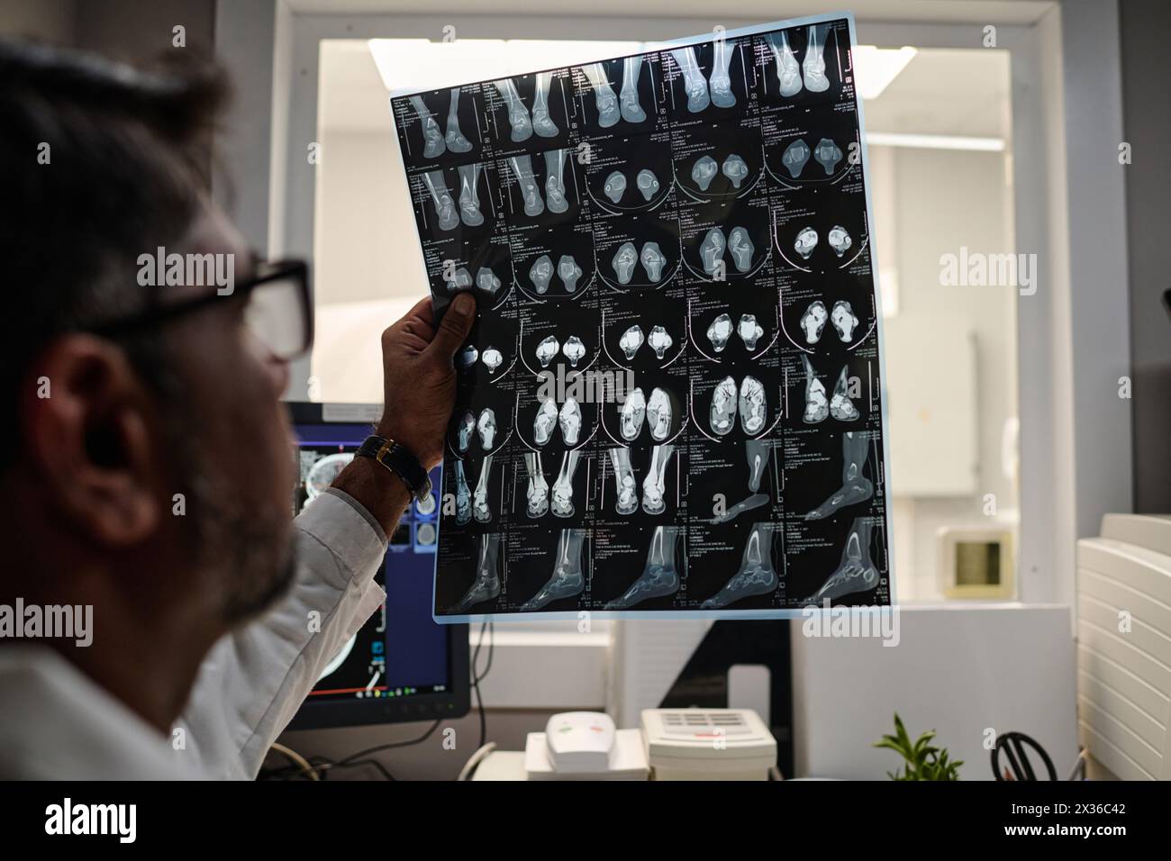 Selektive Fokusnaht eines birazialen männlichen Radiographen, der mit dem Kopf-CT-Röntgenbild arbeitet Stockfoto