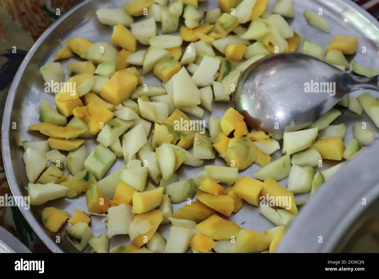 Rohe Mangobeizungszubereitung in der indischen Küche mit Stahlutensilien Stockfoto