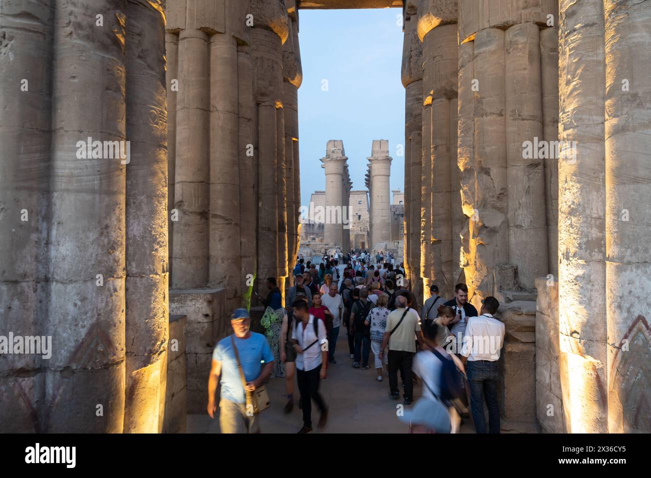 Luxor, Ägypten - 25. November 2023: Touristen besuchen den berühmten Luxor-Tempel in Ägypten mit der beeindruckenden Großen Kolonnadenhalle in der Abenddämmerung Stockfoto