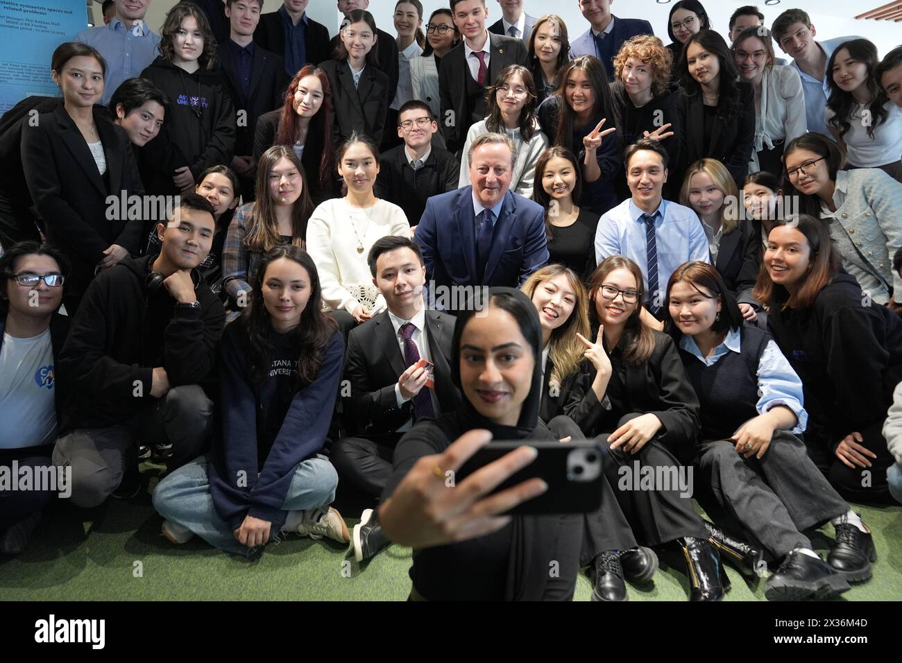 Außenminister Lord David Cameron posiert für ein Foto mit einer Gruppe von Studenten nach einer Q&A-Sitzung an der Astana IT-Universität in Kasachstan während seiner fünftägigen Tour durch Zentralasien. Bilddatum: Donnerstag, 25. April 2024. Stockfoto