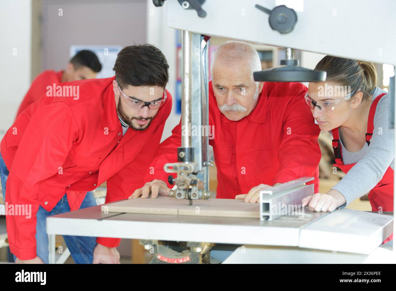 Lehrling und Ingenieur mit computergesteuerter Schneidemaschine Stockfoto