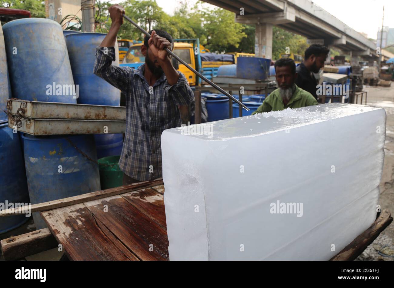 Dhaka. April 2024. Ein Arbeiter zerquetscht einen Eisblock während der andauernden Hitzewelle in Dhaka, Bangladesch, 23. April 2024. Quelle: Xinhua/Alamy Live News Stockfoto