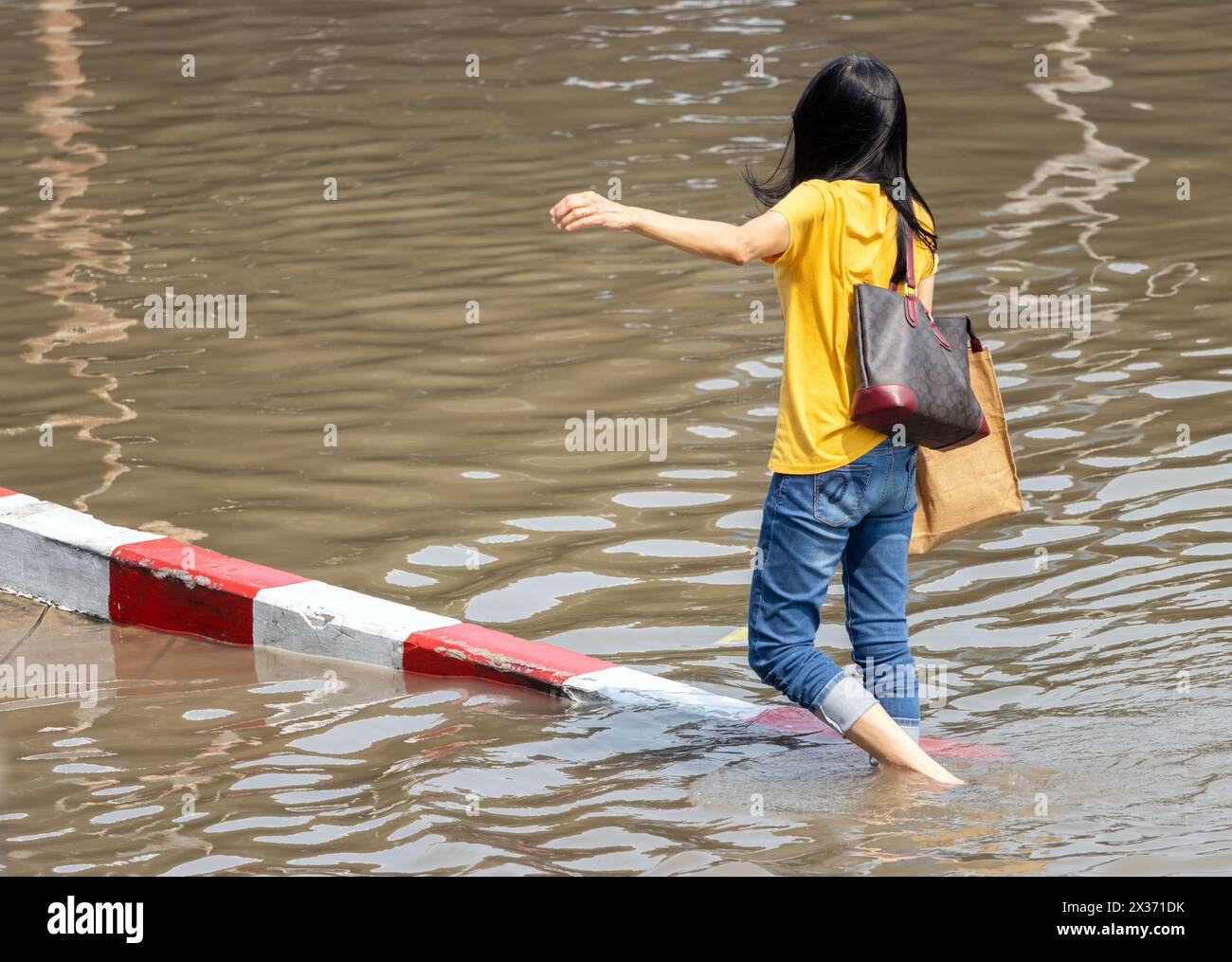 Eine Frau in einer überfluteten Straße, Bangkok, Thailand Stockfoto