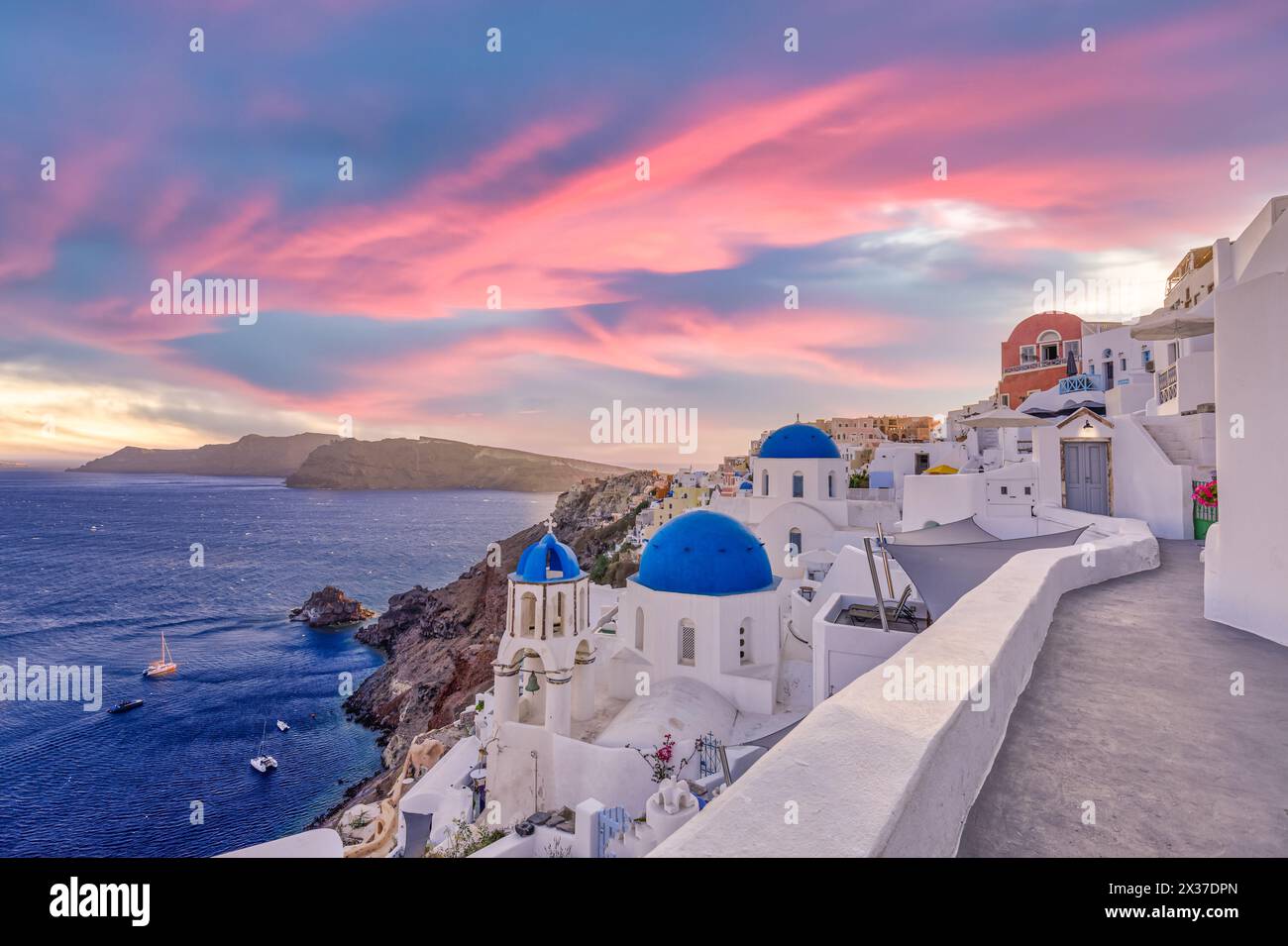Blick bei Sonnenuntergang auf das traditionelle griechische Dorf Oia auf der Insel Santorin in Griechenland. Santorini ist ein bekanntes Reiseziel in Griechenland, der berühmte Sonnenuntergang Stockfoto