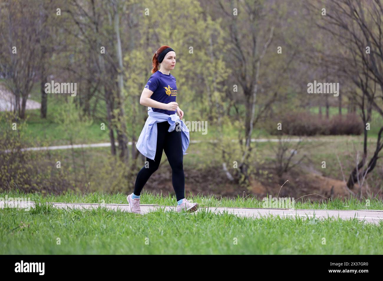 Junge Frau in Sportbekleidung, die im Park läuft, im Frühling trainieren Stockfoto