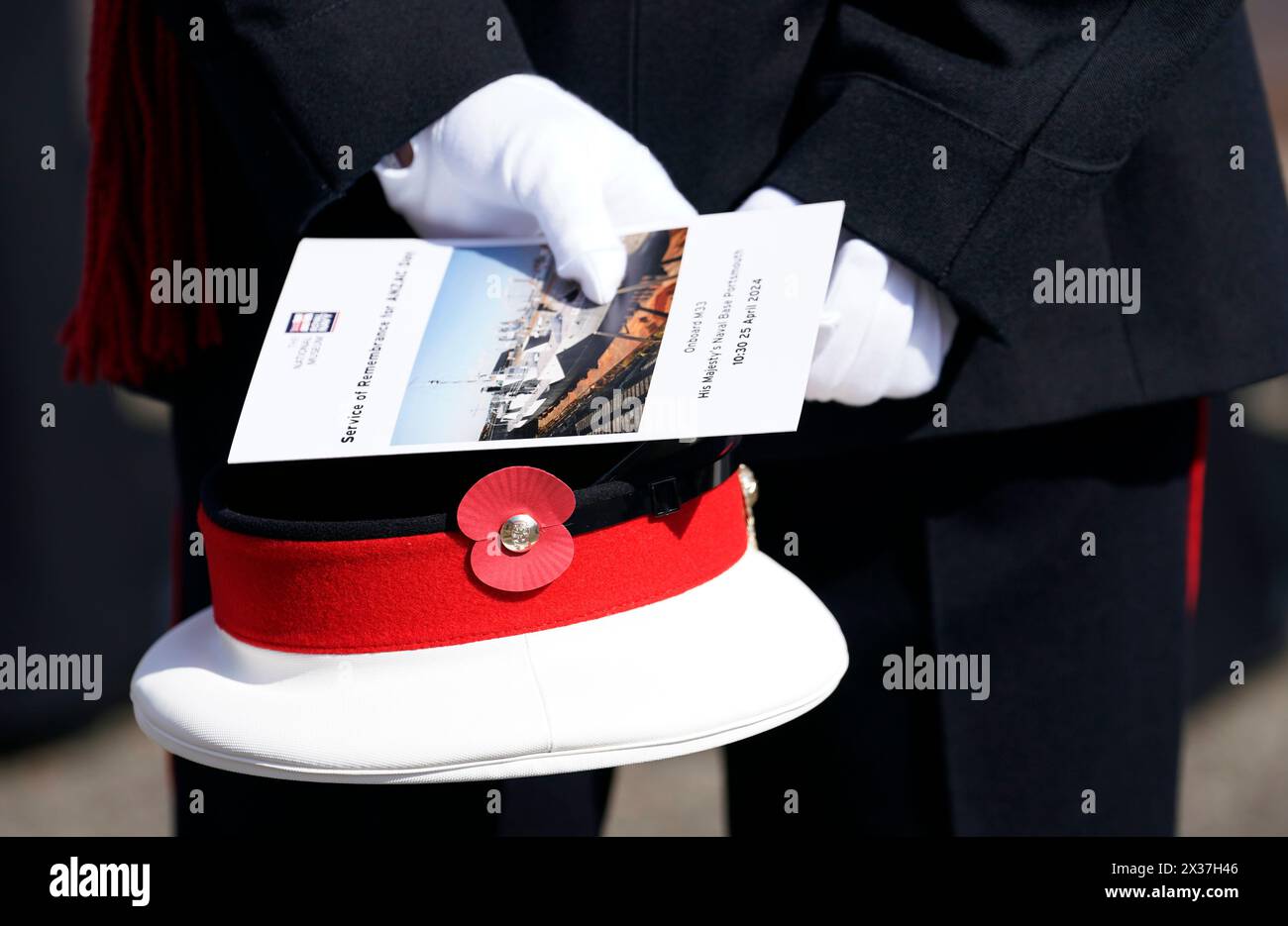 Ein Mitglied der Royal Marines hält seine Kappe und einen Dienstbefehl während eines Gedenkgottesdienstes am Anzac Day an Bord der HMS M.33, dem einzigen überlebenden Schiff der Gallipoli-Kampagne, im National Museum of the Royal Navy in Portsmouth Historic Dockyard. Bilddatum: Donnerstag, 25. April 2024. Stockfoto