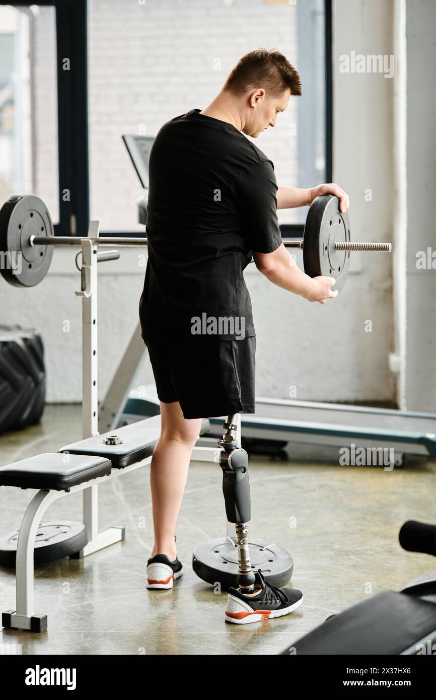 Ein Mann mit einer Beinprothese, der eine Maschine im Fitnessstudio benutzt, um Kraft aufzubauen und die Mobilität zu verbessern. Stockfoto