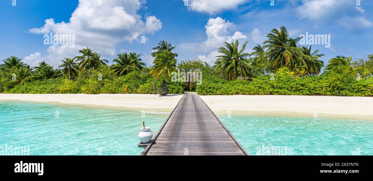 Wunderschöne tropische Landschaft im Hintergrund, luxuriöse Sommerreisen und Urlaub. Hölzerner Pier in die Insel vor blauem Himmel mit weißen Wolken, Panoramablick Stockfoto