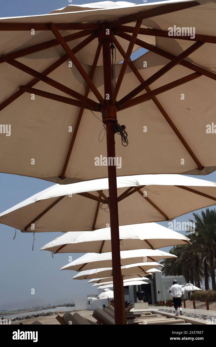 Leere Sonnenliegen und Sonnenschirme am Strand im Chedi Hotel Muscat Oman Stockfoto